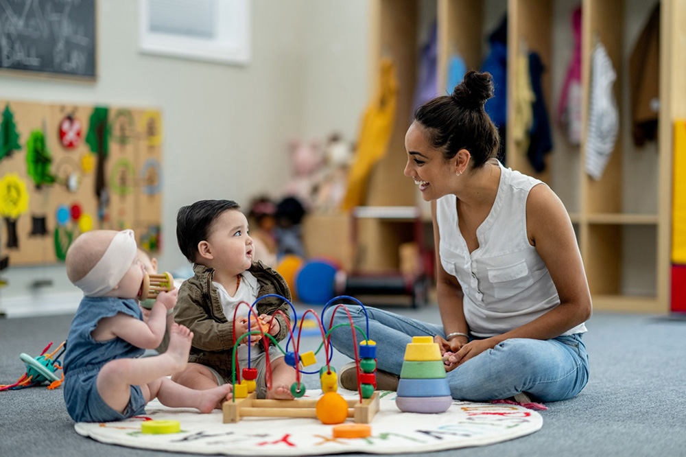 Early Childhood Educator with infant children in a daycare classroom